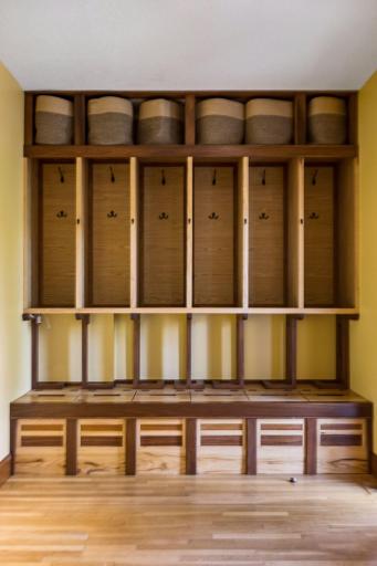 A beautifully designed foyer features custom built-ins with six individual lockers, pullout shoe storage, upper baskets, and gorgeous woodworkâan ideal combination of style and everyday functionality.