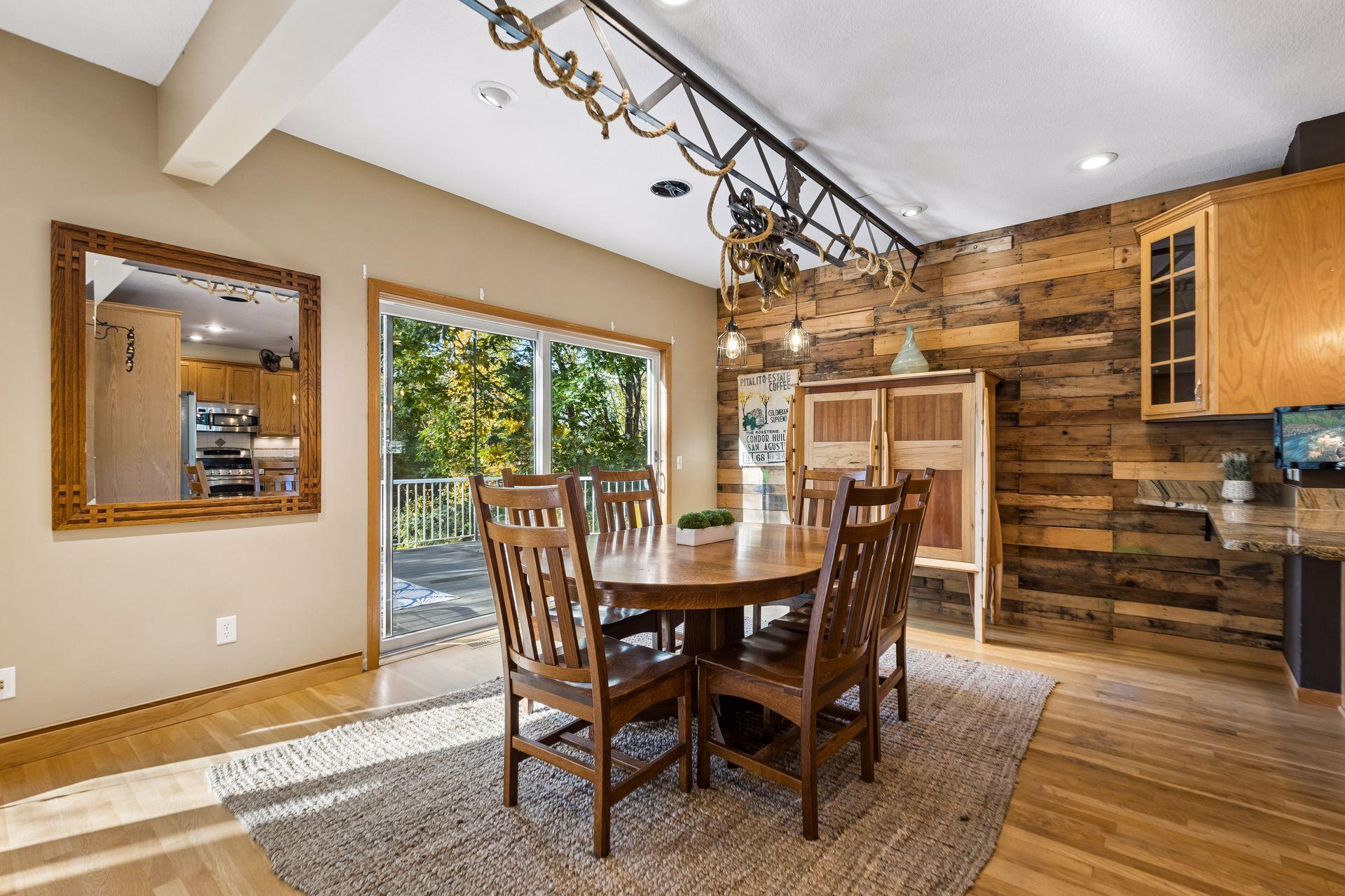 The spacious dining area easily accommodates a large table, with oversized sliding glass doors leading to the deck and beautiful custom lighting overhead.