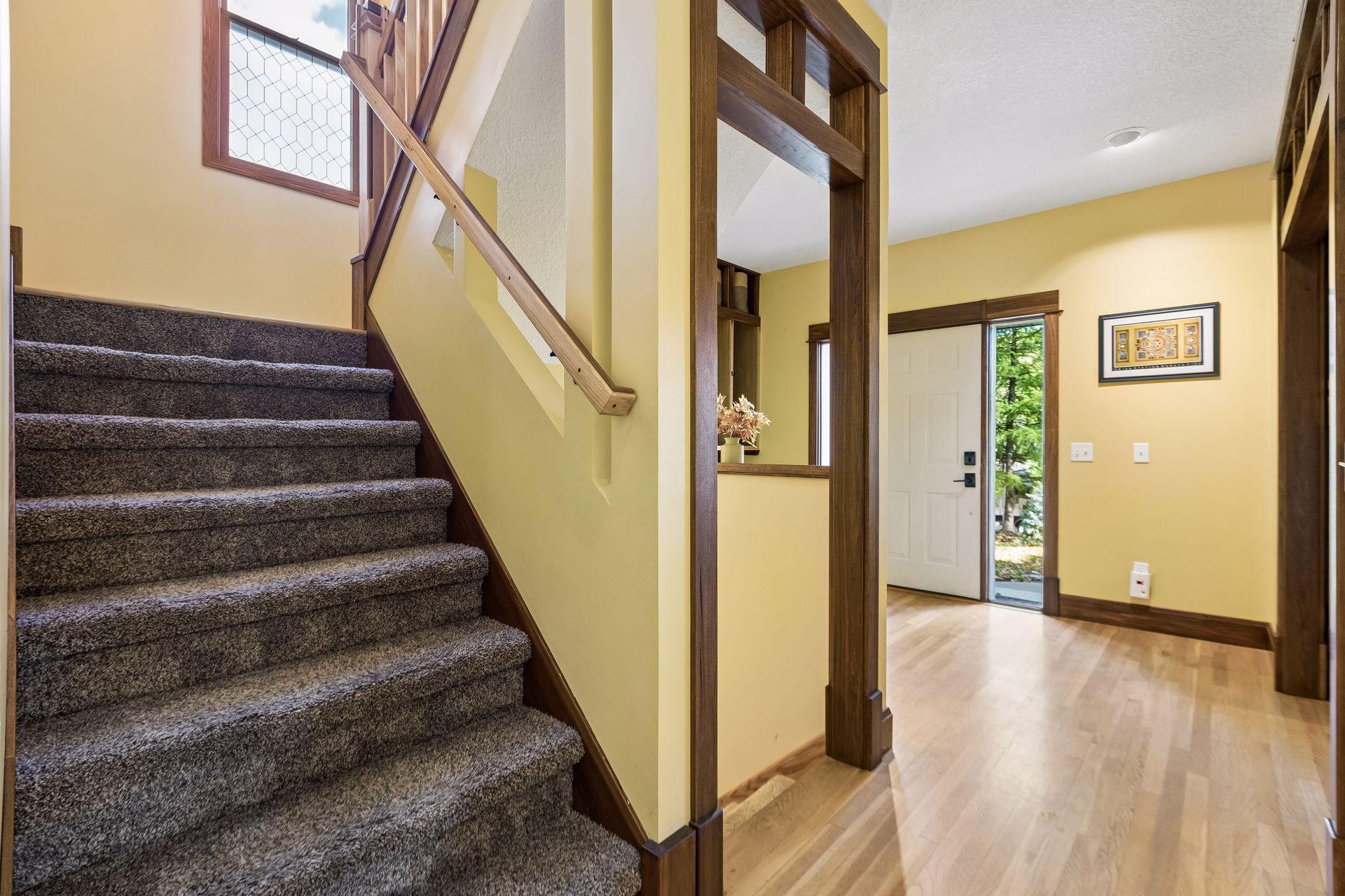 Beautiful craftsmanship continues along the staircase leading to the upper level, with gorgeous woodwork and architectural details.