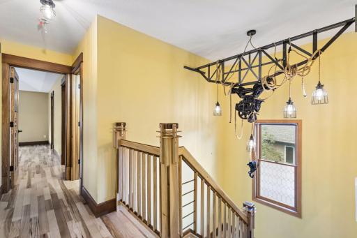 Another stunning custom lighting feature welcomes you to the upper level, where you'll find four spacious bedrooms and two bathrooms.