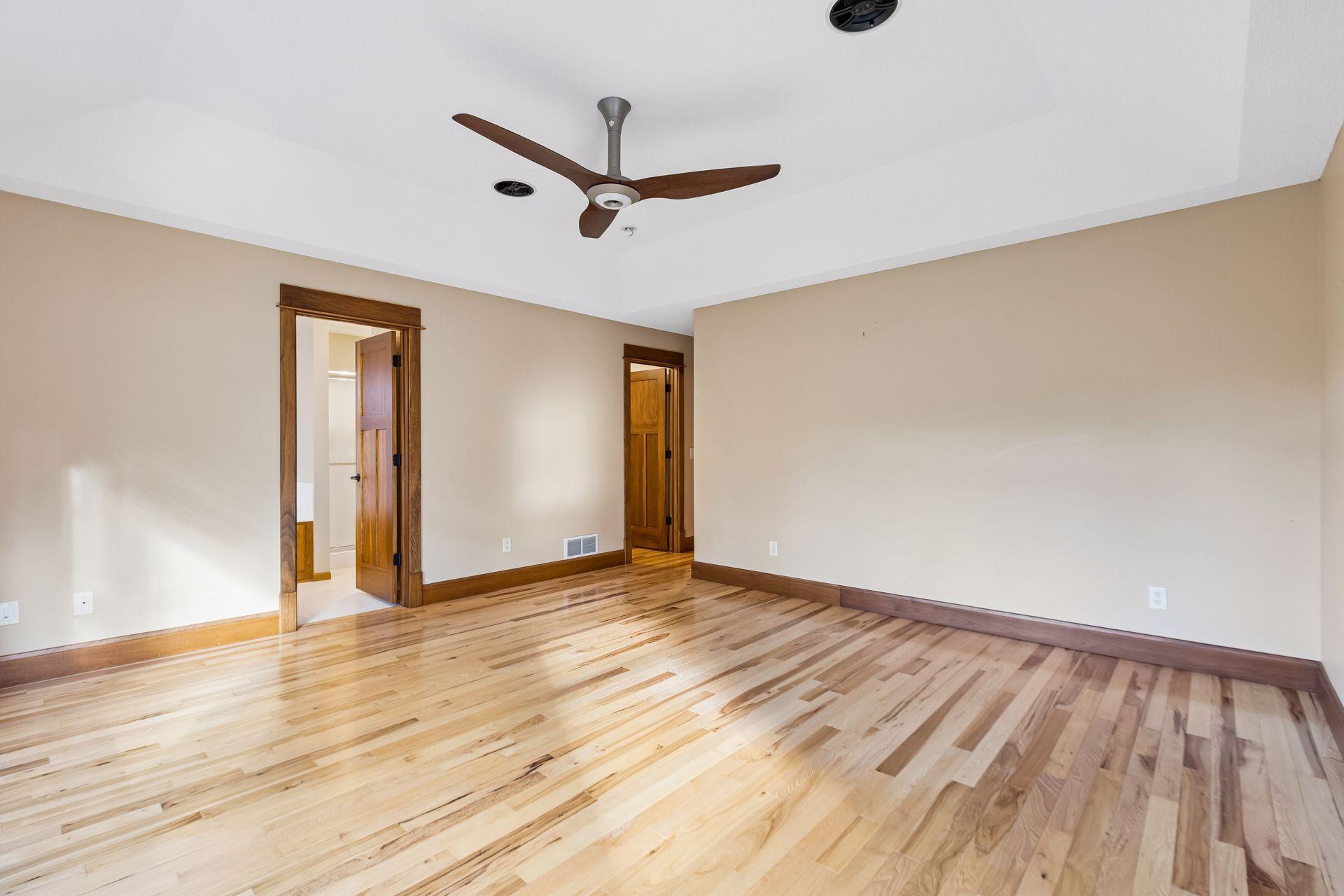Another view of the expansive primary suite, featuring a generous walk-in closet and private full bathroom.