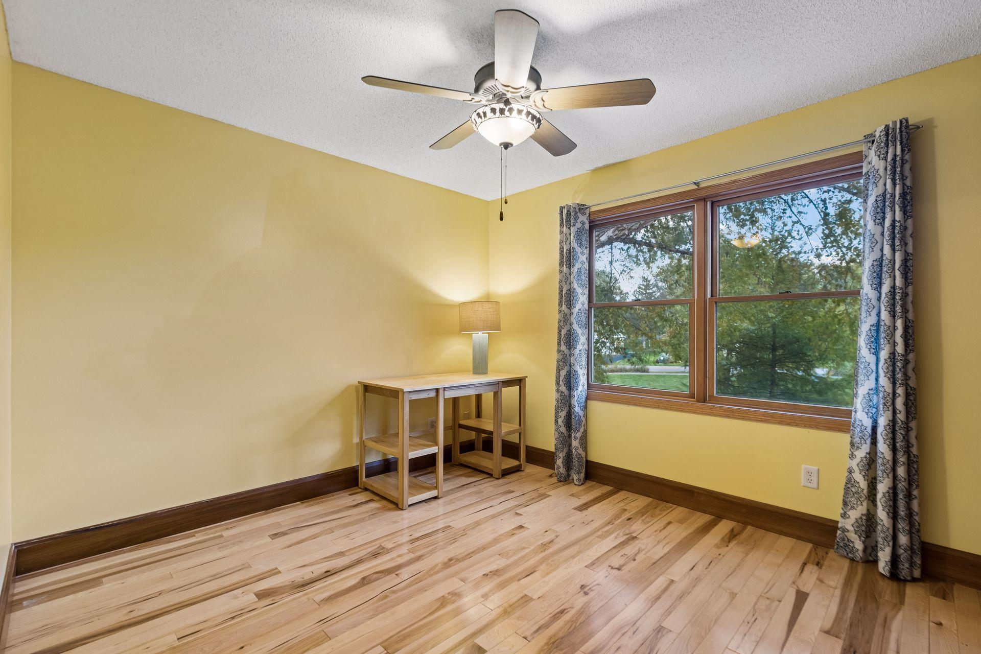 Upper-level bedroom two offers comfortable living space with beautiful hardwood flooring.