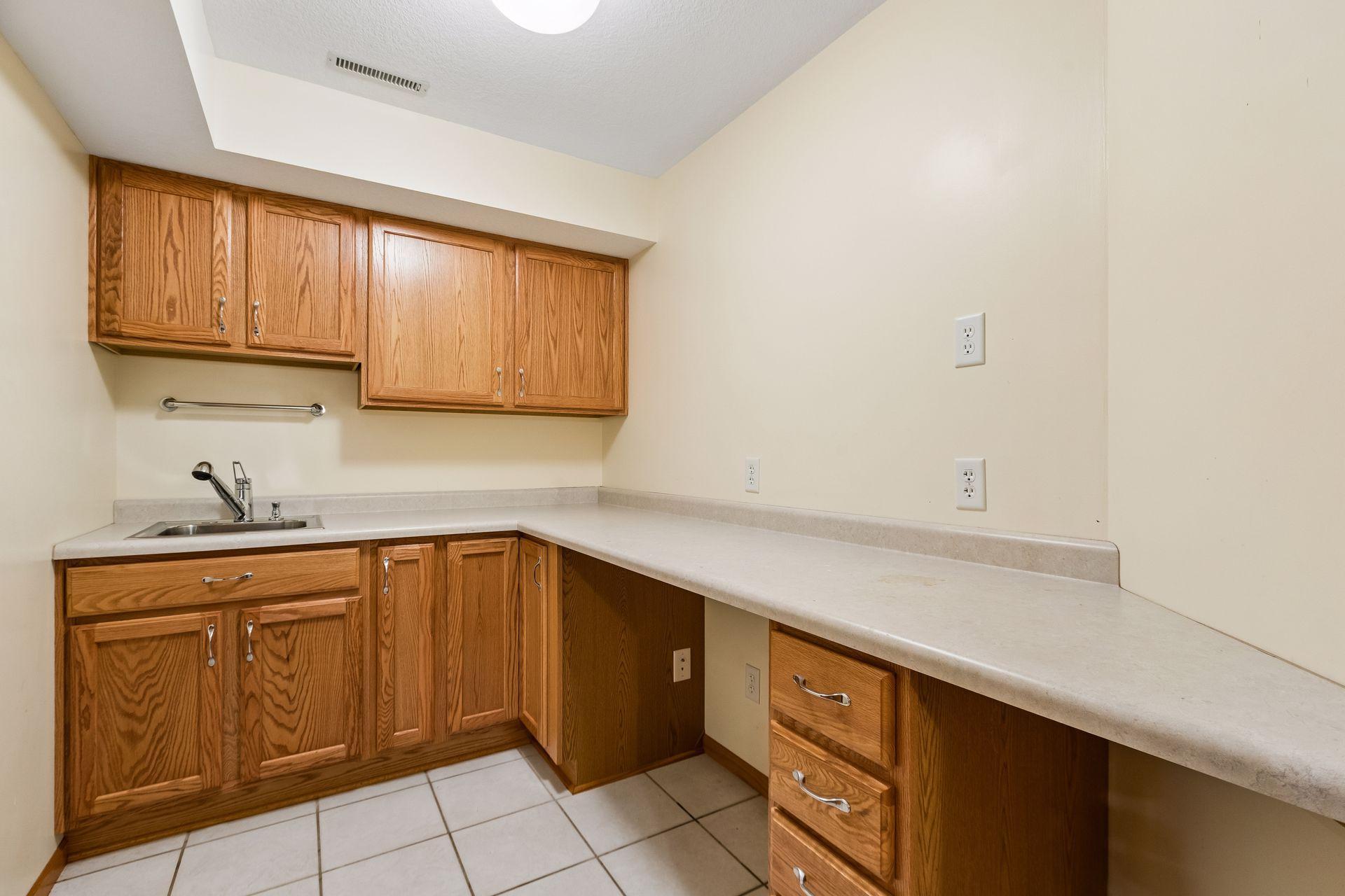 A versatile craft or hobby room offers creative possibilities, with potential to reconfigure the space for a future wet bar.