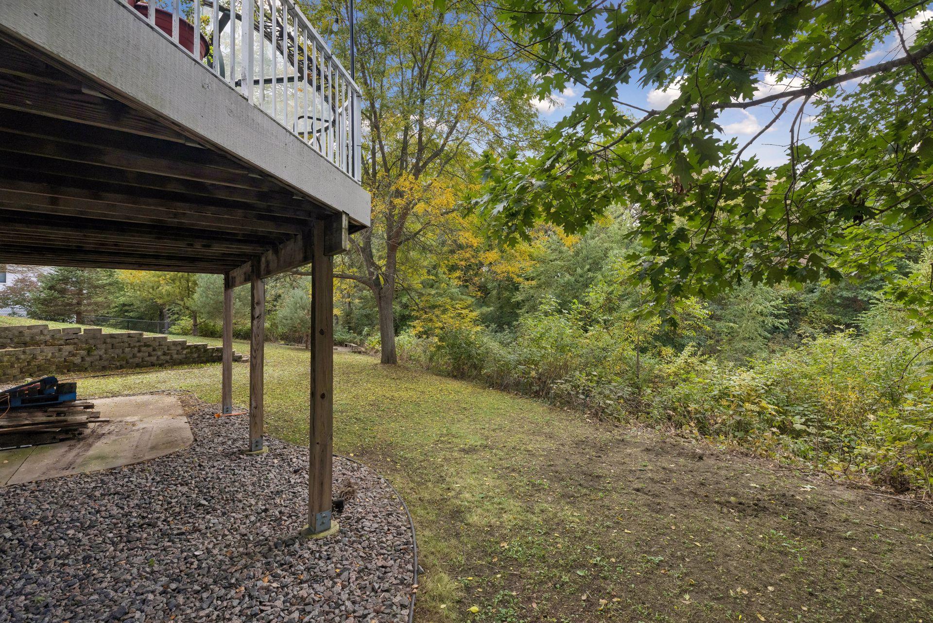 Enjoy incredible privacy from the patio beneath the deck, where mature trees, peaceful pond views, and natural surroundings create a serene backyard retreat.