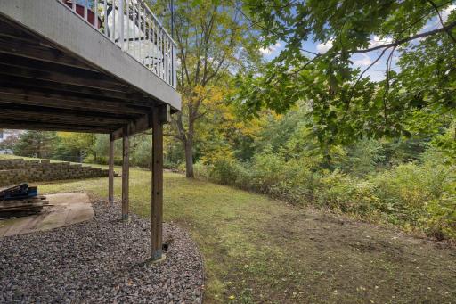 Enjoy incredible privacy from the patio beneath the deck, where mature trees, peaceful pond views, and natural surroundings create a serene backyard retreat.