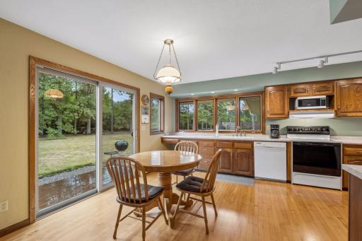 The kitchenâs casual dining area features hardwood flooring, chandelier lighting, and Andersen sliding door (new 2025) access to the backyard.