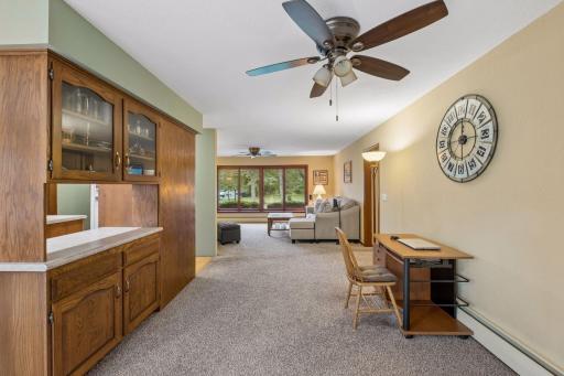 A built in buffet pass through to the kitchen adds character and storage to the formal dining room, complemented by carpet and a ceiling fan with light.