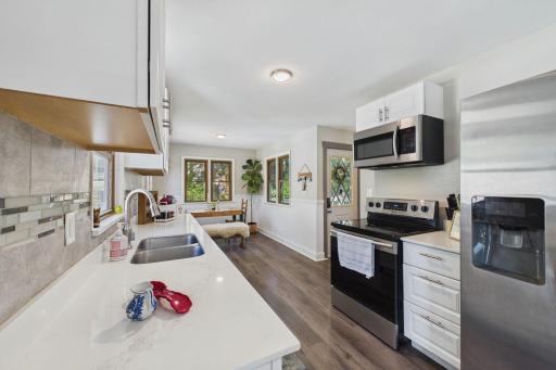 Bright Kitchen with Quartz Counters, Stainless Appliances & Three-Sided Windows