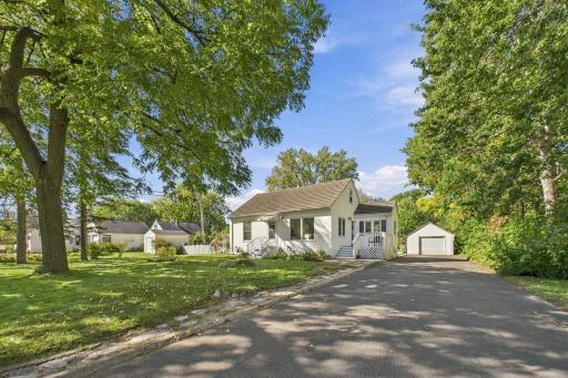 Daylight Front Exterior with Lush Landscaping & Detached Garage