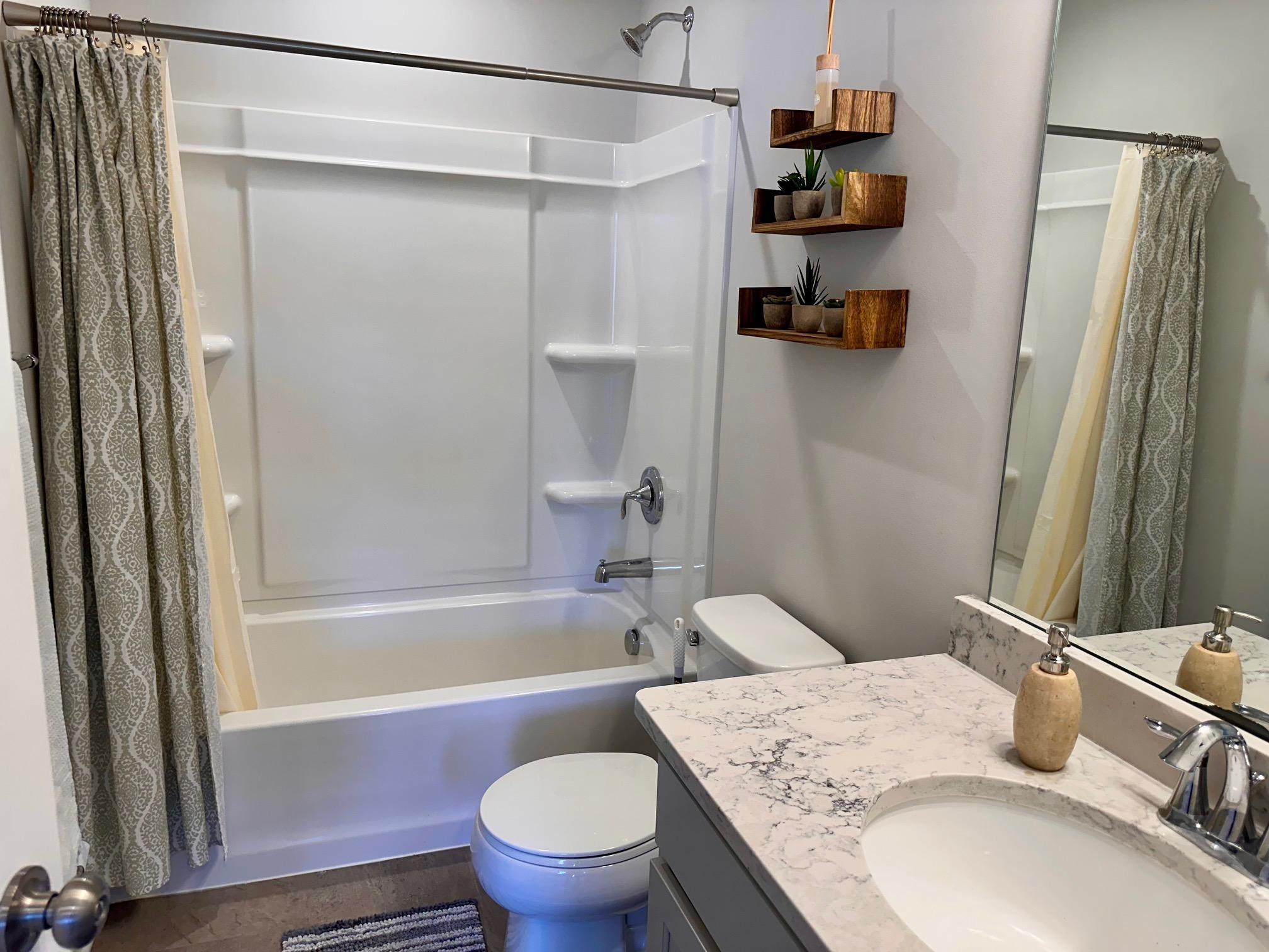 Full bath on the upper level with quartz countertops and tiled floors.jpeg