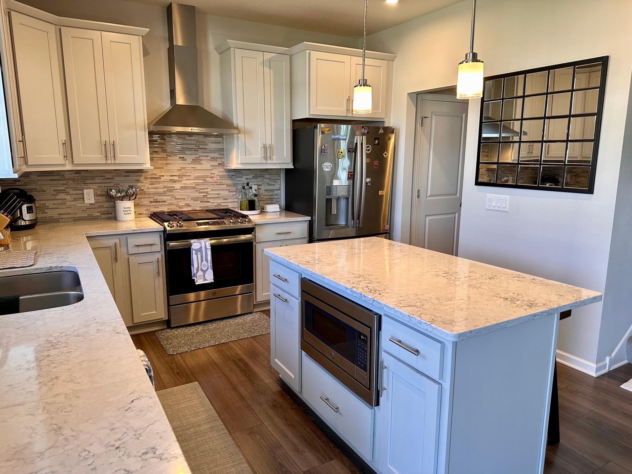 Sun-filled kitchen, microwave built into kitchen island and beautiful engineered hardwood floors.jpeg