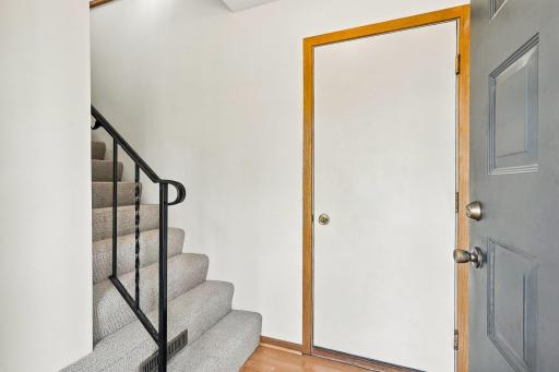 Foyer with brand New Carpeted stairs and new bi-fold doors to closet!