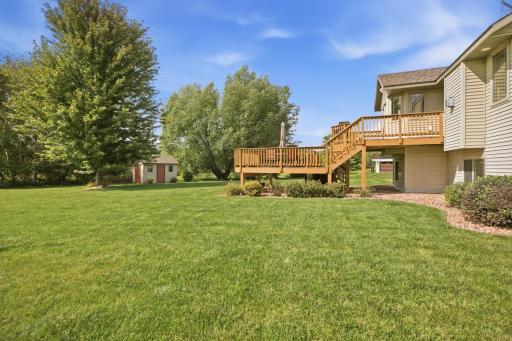 Outdoor living continues with a two-tier deck overlooking a beautifully landscaped backyard with no backyard neighbors.