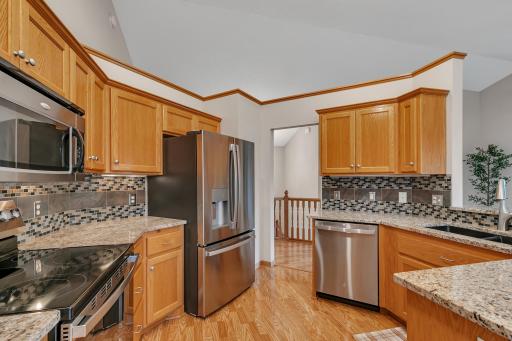 It features granite countertops, a tiled backsplash, and stainless steel appliances (refrigerator new Dec 2024, range & dishwasher new Jan 2026).