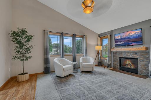 The upper-level living spaces offer a warm, comfortable atmosphere with vaulted ceilings, ceiling fans, and abundant recessed lighting.