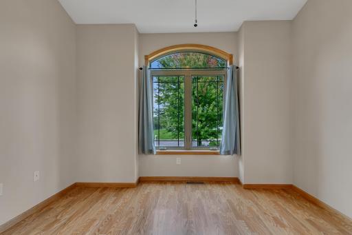 Office just off the living room with a ceiling fan for airflow and a large picture window for natural light.