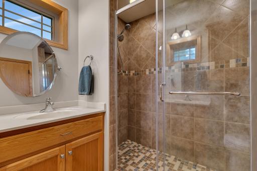 There is also a fully tiled walk-in shower with dual showerheads, dual recessed lights, and a sliding glass door.