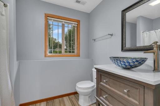 The lower-level bathroom offers a vessel sink vanity, and a shower with a convenient built-in seat.