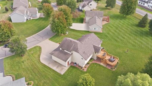 A concrete driveway, mature landscaping, and the private backyard setting complete the exterior.