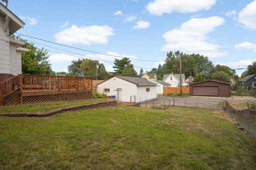 Deep fenced backyard with a large deck and detached garage