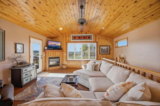 Awesome sunshine through the clear glass door leading out to the deck. Notice the up north lake feel of the knotty pine wood on the wall and the ceiling.