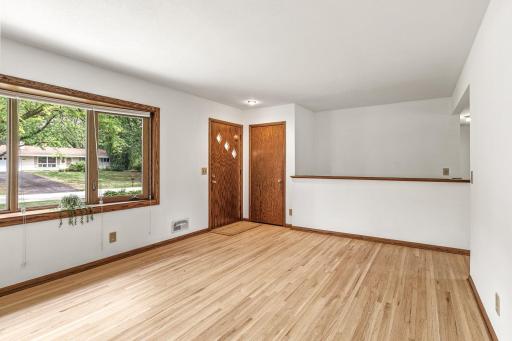 Main level entrance opens to living room with newly sanded and refinished original hardwood floors.