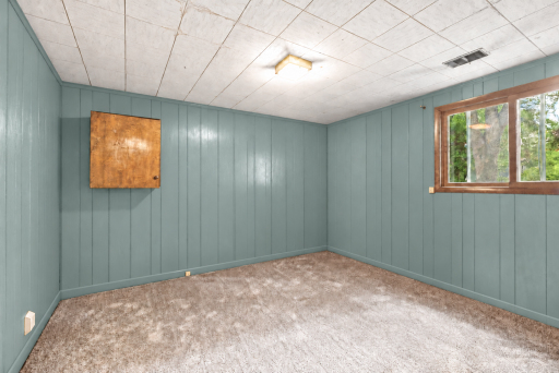 Private 4th bedroom on the lower level. This photo has been digitally enhanced.