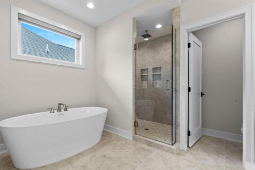 Finished with a walk-in shower featuring a stunning tile surround.