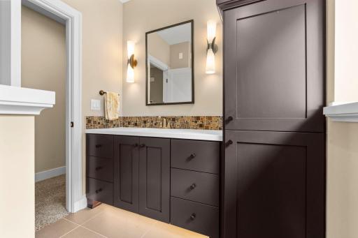 A 3/4 bathroom with a convenient linen cabinet located on the lower level .