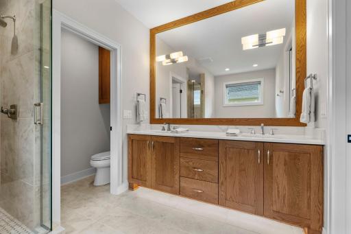 En-suite bathroom featuring a dual vanity and a comfortable, thoughtfully designed space.