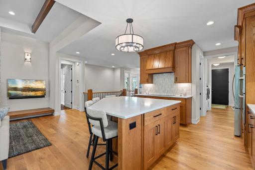 Beautiful tile backsplash paired with a large center island offering additional storage, generous counter space, meal prep, entertaining, and casual seating.