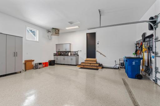 Complete with built-in shelving, utility sink, separate water spigot, extended ceiling height, and floor drain.