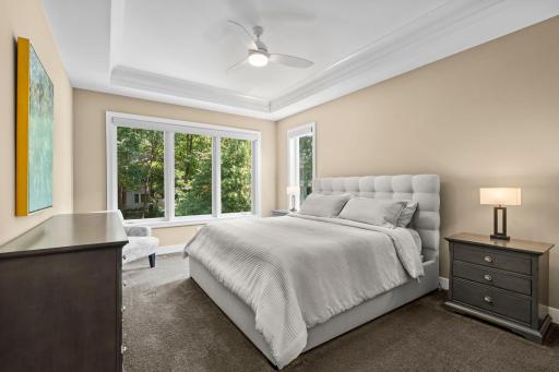 Primary suite just off the living room, featuring natural light, backyard views, and a spacious walk-in closet.