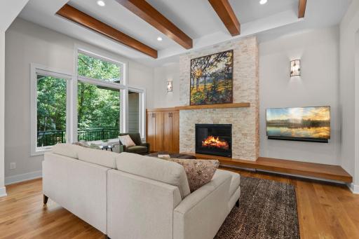 Living room just off the kitchen features a vaulted 11' ceilings and beautiful wood beams, creating a warm and inviting gathering space.