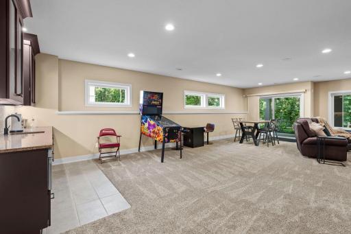 Flexible gathering space with multiple seating areas, ideal for a game area or additional lounge space near the wet bar.