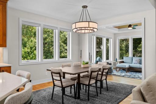 Dining space just off the kitchen and living room, surrounded by windows overlooking the side yard and finished with statement lighting.