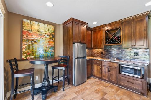 Microwave and 3/4 fridge in bar area.
