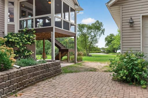 The retaining wall along driveway leads to screen porch stairs.
