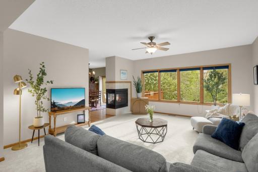 Large Living Room features brand-new carpet and four oversized windows overlooking the beautiful, tree-lined backyard. The three-sided gas fireplace adds warmth and character while connecting the Living Room with the adjoining Dining area.