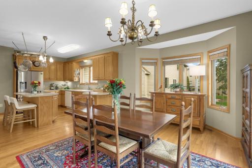 Hardwood floors flow throughout the Dining area and Kitchen, creating a spacious and connected layout. Multiple windows bring in great natural light, while the nearby Kitchen island provides additional seating and gathering space.