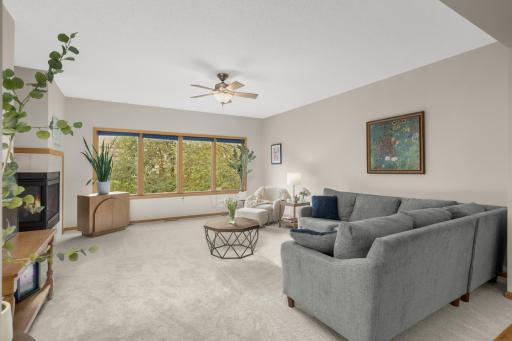 Spacious Living Room offers plenty of room for multiple seating areas and features brand-new carpet. Four oversized windows overlook the mature trees in the backyard and bring in an abundance of natural light.