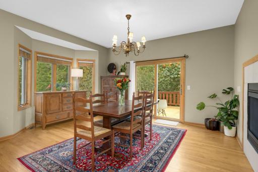 Spacious Dining Room features hardwood flooring, multiple windows and a sliding glass door leading directly to the deck. The three-sided gas fireplace is shared with the Living Room, creating a warm connection between the two spaces.