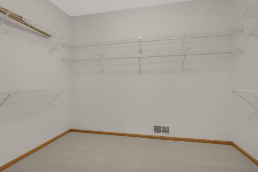 No shortage of storage here! Large Walk-In Closet with shelving on multiple walls for plenty of organization space.