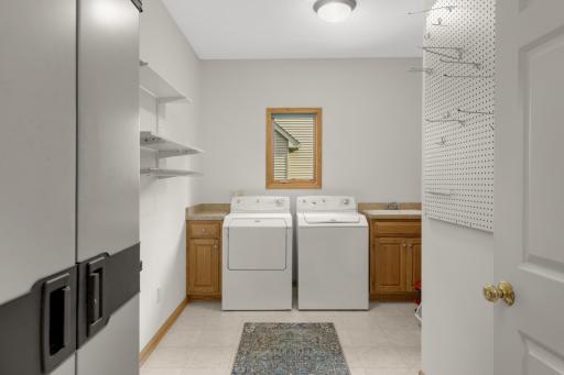 More than just a Laundry Room! Generous space with a utility sink, cabinetry, shelving and plenty of room for additional household storage.