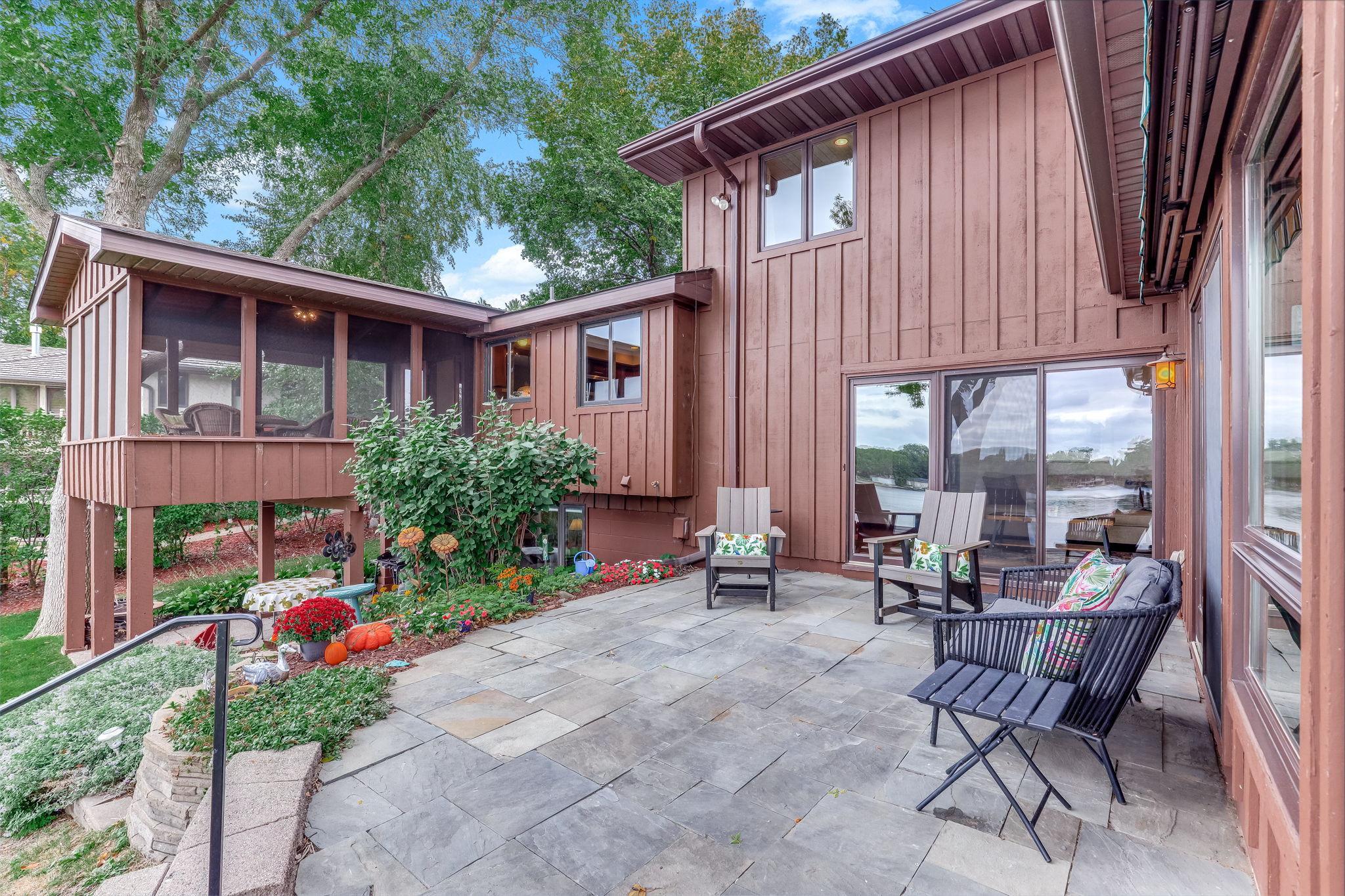 Slate patio with garden beds and an electric, retractable awning for sun protection