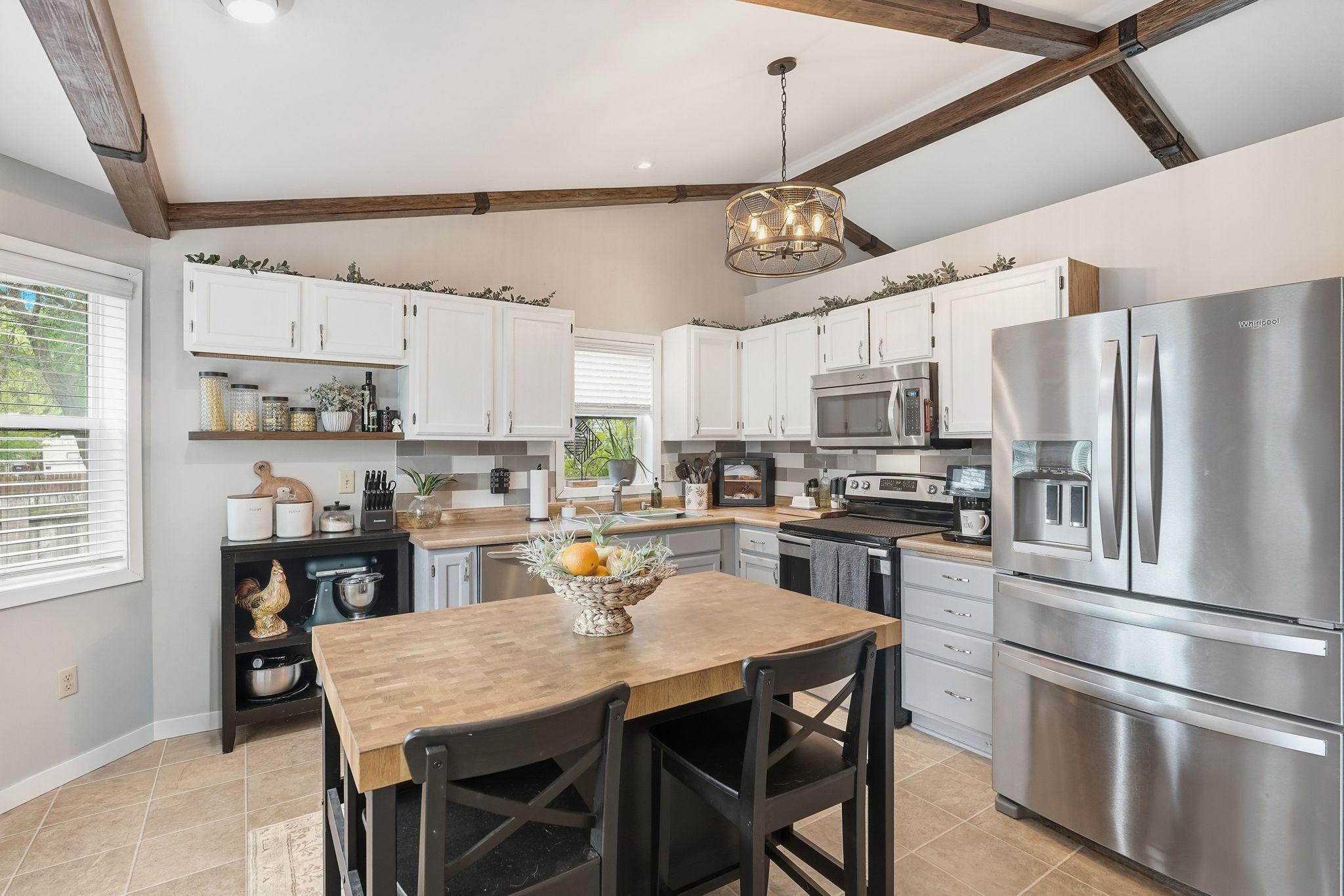 Stainless appliances, island, and bay window for added light.