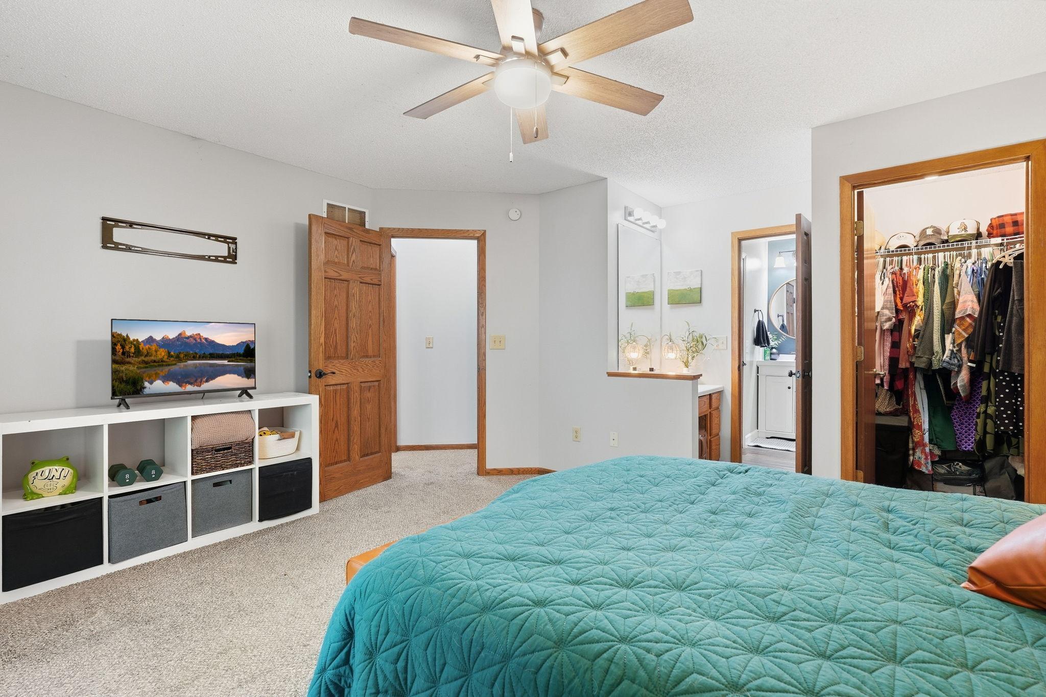 Primary bedroom with vanity, walk-in closet, and walk though to connected bathroom.