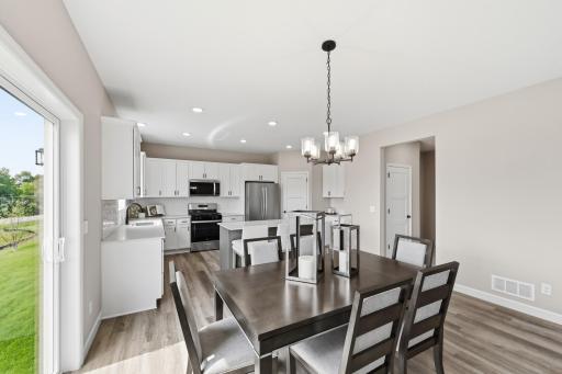 Dining space that flows into kitchen. *photos taken of previously completed home, not all finishes & options the same.*