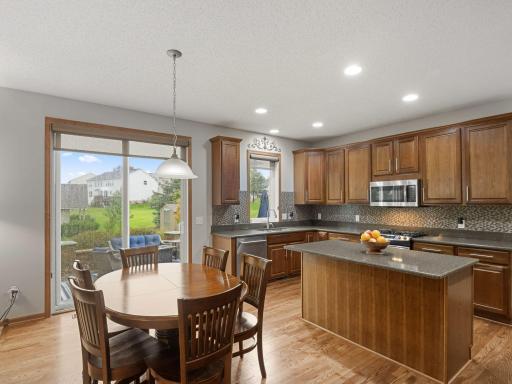 Kitchen & Informal Dining â Open kitchen and dining area with hardwood floors and direct access to the backyard patio.