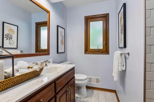 warm and clean full main bath has solid wood cabinets.